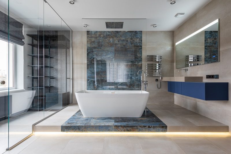 A bathroom with a large tub and tiled walls.