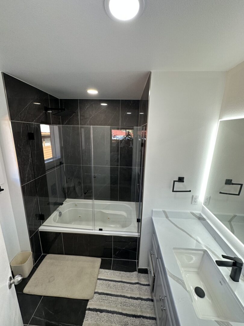 A bathroom with black tile and white walls.